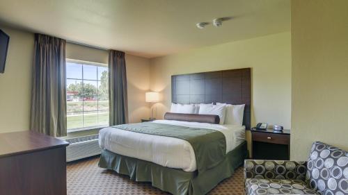 a hotel room with a bed and a window at Cobblestone Inn & Suites-Kersey in Kersey