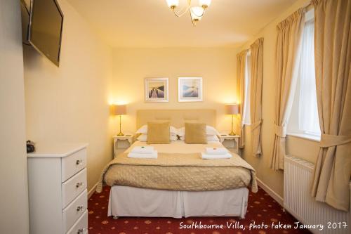a bedroom with a bed with two pillows on it at The Southbourne Villa in Torquay
