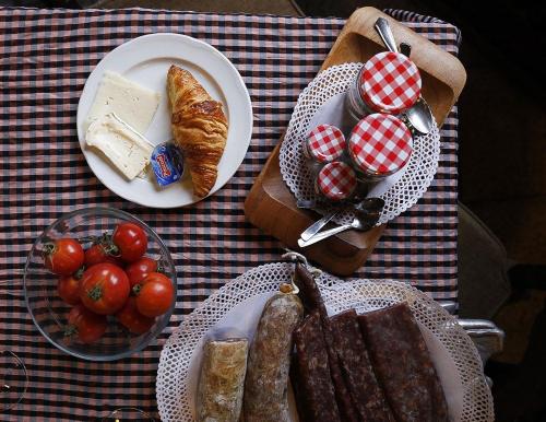 un tavolo con un piatto di cibo, pane e pomodori di Hotel Poldo a La Guingueta
