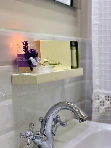 a bathroom sink with a faucet and a shelf above it at B&B ALVINO in Bientina