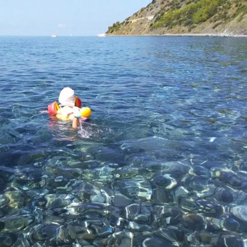 a child in the water with a raft in the water at Villa Calamona in Acciaroli