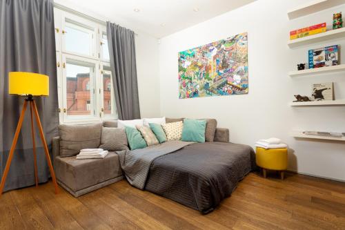 uma sala de estar com um sofá e uma pintura na parede em Designer Vinohrady Apartments em Praga