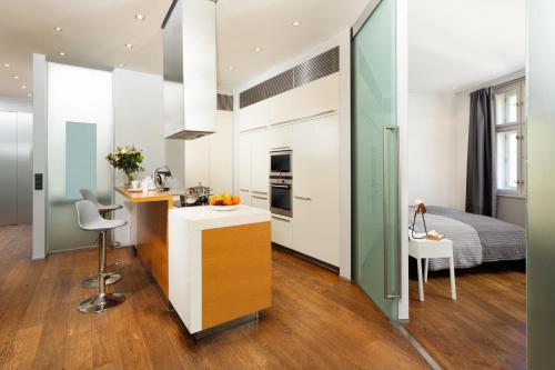 uma cozinha e um quarto com uma cama em Designer Vinohrady Apartments em Praga