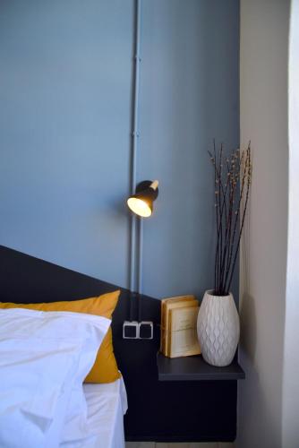 a bedroom with a bed with a vase and a lamp at Habit in Ermoupoli