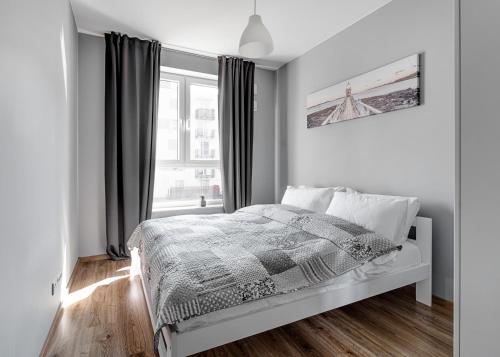 - une chambre blanche avec un lit et une fenêtre dans l'établissement Warszawa-Włochy Brilliant Apartment, à Varsovie