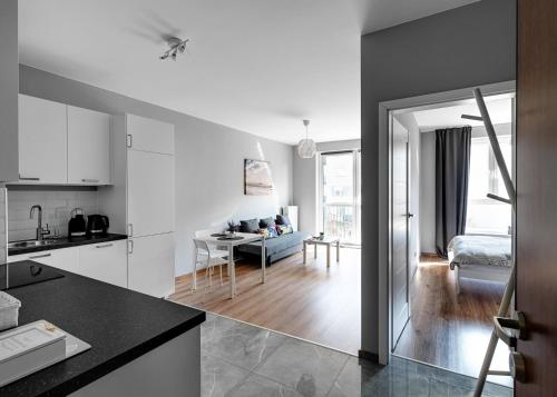 Il comprend une cuisine et un salon avec une table. dans l'établissement Warszawa-Włochy Brilliant Apartment, à Varsovie