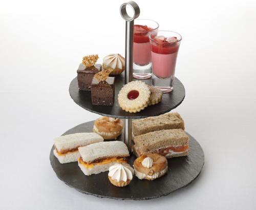 a three tiered tray with sandwiches and donuts and drinks at Kilcamb Lodge Hotel in Strontian