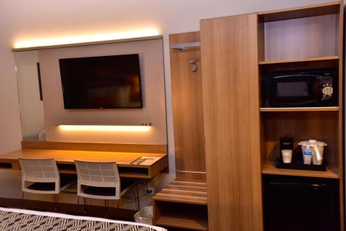 a room with a desk with two chairs and a television at Microtel Inn & Suites by Wyndham Cuauhtemoc Campos Menonitas in Cuauhtémoc