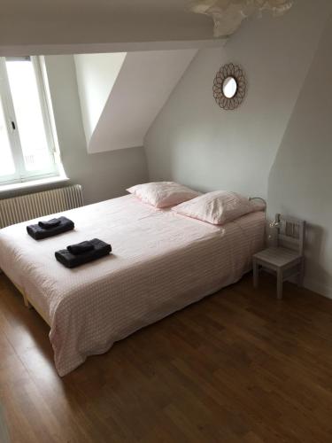 a bedroom with a bed with two black towels on it at L'Autruche Verte in Arleux-en-Gohelle