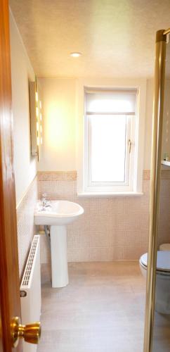 a bathroom with a sink and a window at Old Nurses Cottage in Skeabost