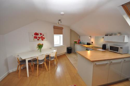 een keuken en eetkamer met een tafel en stoelen bij The Coach House Studio Apartment in Leamington Spa
