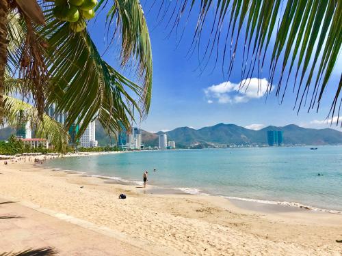 a person standing on a beach near the water at Stay in Nha Trang Apartment in Nha Trang