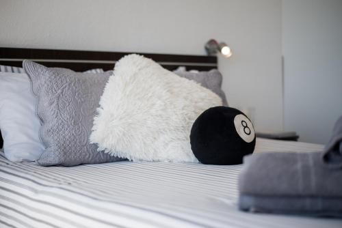 a white stuffed animal laying on a bed with pillows at Apartamentos Estudio Nuevo en Puerto de la Cruz in Puerto de la Cruz