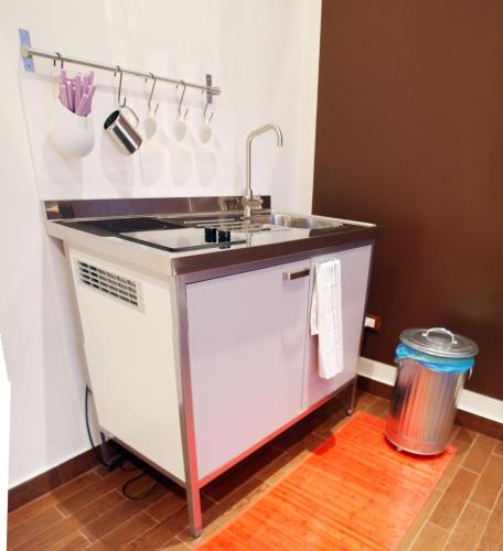 a kitchen counter with a sink and a trash can at Garden Holiday in Marina di Melilli