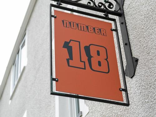 a sign on the side of a building with the number at Number 18 in Conwy