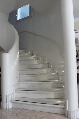 una escalera en un edificio con paredes y techos blancos en Hotel Ivana, en Misano Adriatico