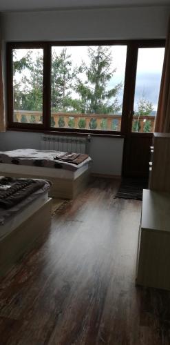 a room with two beds and a large window at EldoSport Hotel in Dospat