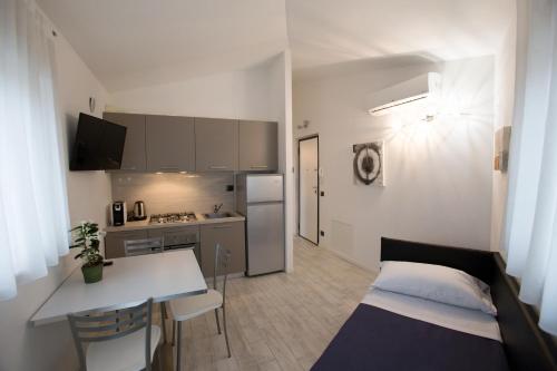 um pequeno apartamento com uma cozinha e uma mesa em Residenza GB Rossi "Residenze del Cuore" em Verona