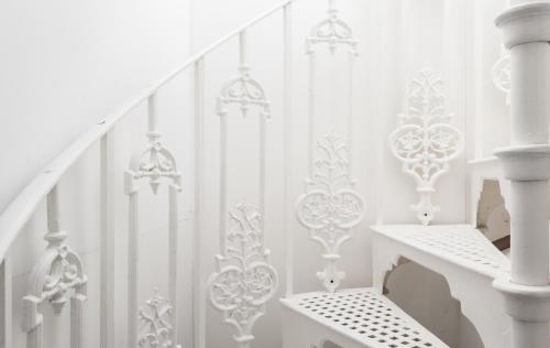 a white staircase with white railings and a stair case at The Marylebone Residence in London