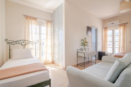 a white room with two beds and a couch at Mimoza in Spetses
