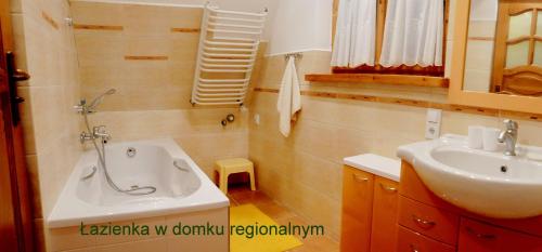 a bathroom with a sink and a bath tub at Domek regionalny Busola in Zakopane