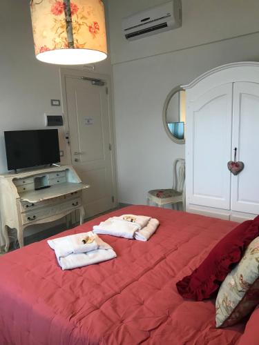 a bedroom with two towels on a red bed at Agriturismo Villa Le Vigne in Montevarchi