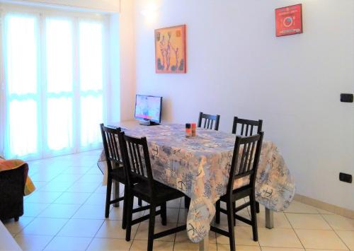 jadalnia ze stołem z 4 krzesłami i tableablish w obiekcie Appartamento Angela w mieście Pietra Ligure