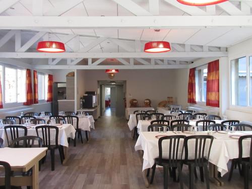 une salle à manger avec des tables, des chaises et des lumières rouges dans l'établissement Village vacances de Marc, à Auzat