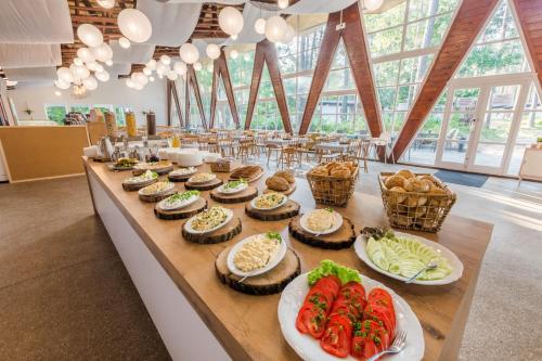 Una mesa con pastelitos y otros alimentos encima. en BURSZTYNOWO Ośrodek Wczasowy, en Sztutowo