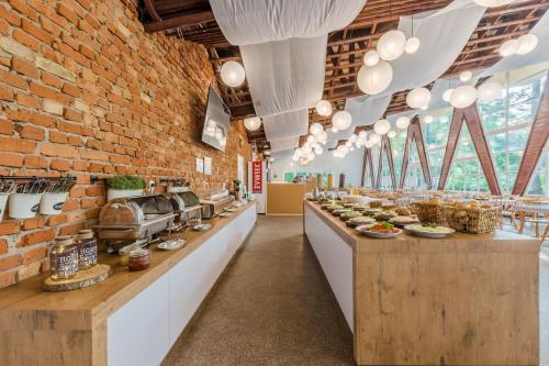 Un restaurante con una pared de ladrillos y un mostrador con comida. en BURSZTYNOWO Ośrodek Wczasowy, en Sztutowo