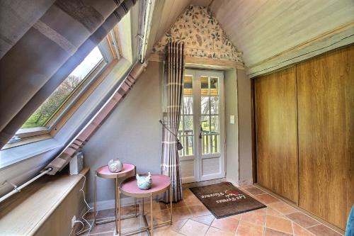 a small room with two stools in front of a window at Les Fermes de Florence Bien être et nature in Les Champeaux