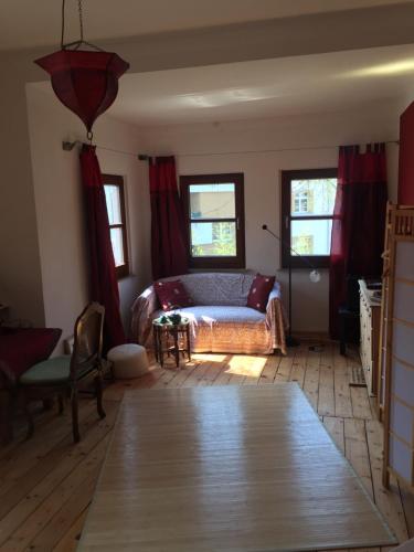 ケルンにあるMessezimmer Nähe Zentrumのベッドルーム1室(赤いカーテンとテーブル付きのベッド1台付)