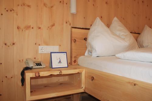 a bedroom with a bed and a phone on a table at Bio-Pension Bliem in Altenmarkt im Pongau