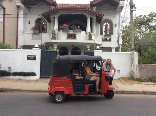 two people sitting in a small car on a street at Angel villa in Negombo
