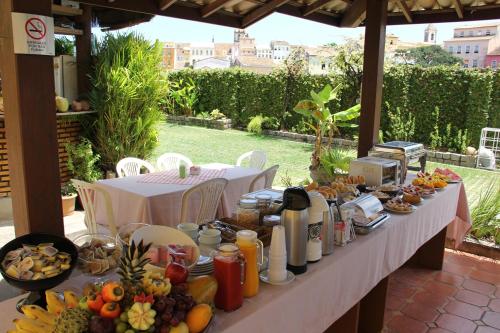 a table topped with plates of food and drinks at Hotel Pousada da Mangueira in Salvador