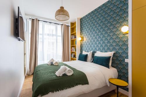 - une chambre avec un grand lit et des serviettes dans l'établissement CMG Charonne / Voltaire III, à Paris