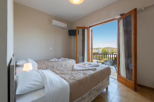 1 dormitorio con 2 camas y balcón en Maria Apartments Studios Epidavros, en Palaia Epidavros