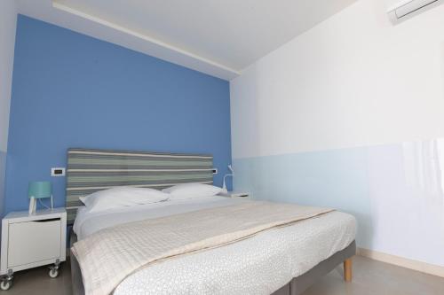 a bedroom with a bed with a blue wall at Il Giardino di Agata in Mascalucia