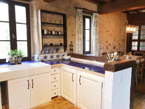 米爾普瓦的住宿－Hameau de Montcabirol，厨房配有白色橱柜和水槽
