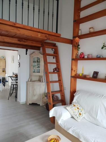 a bedroom with a loft bed and a ladder at Appartamento " CENTRAL" in Arzachena