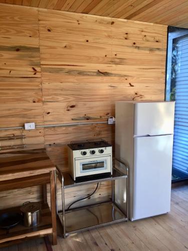 a kitchen with a refrigerator and a stove at Cabañas Isla San Jose in Tigre
