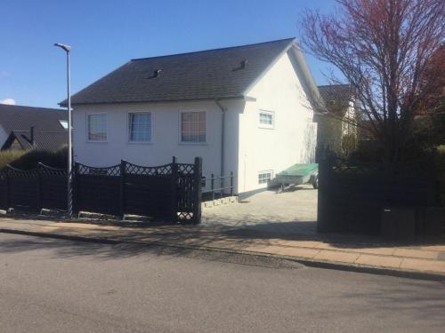 a white house with a black fence in front of it at Cozy room in Kolding