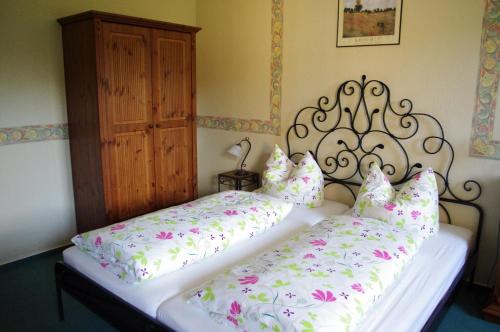 una camera con due letti con lenzuola bianche e fiori rosa di La Petite Provence a Leisnig