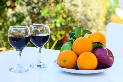 zwei Gläser Wein und eine Schale Obst auf dem Tisch. in der Unterkunft Maria Apartments Studios Epidavros in Antikes Epidauros