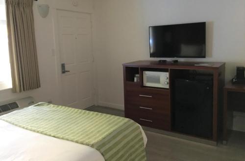 a bedroom with a bed and a flat screen tv at Diablo Mountain Inn Walnut Creek in Walnut Creek