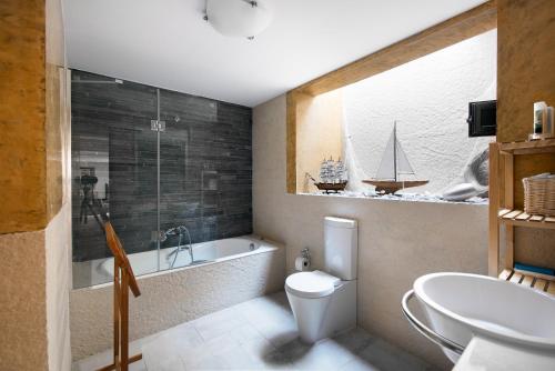 a bathroom with a tub and a toilet and a sink at Possidi Villa Glamour by Luxlikehome in Possidi