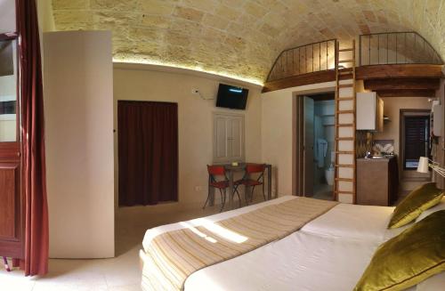 ガラティーナにあるDi Volta in Volta - Affitti breviのベッドルーム1室(ベッド1台、テーブル、椅子付)