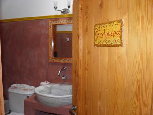 a bathroom with a sink and a mirror at Kytherian Traditional Home in Friligkianika