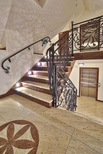 a staircase with a wrought iron railing in a house at Grand Podhale Resort&Spa Zakopane - Jacuzzi - Sauna fińska i Łaźnia parowa - Widok na Tatry in Zakopane