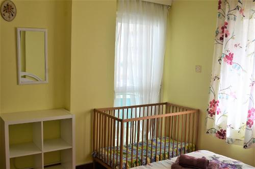 a baby crib in a room with a window at LIRA in Larnaka
